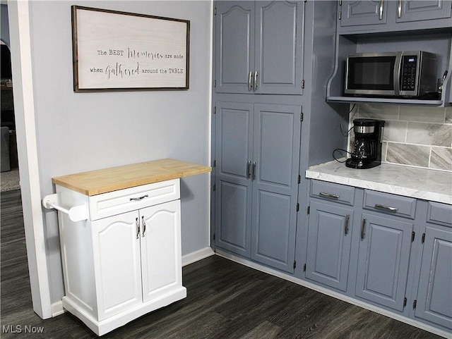 kitchen featuring butcher block counters, dark wood-type flooring, and tasteful backsplash