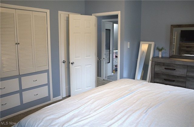 bedroom with a closet and dark colored carpet