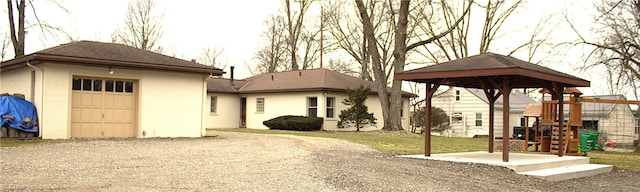 view of front of home with a garage, a gazebo, an outdoor structure, and a playground