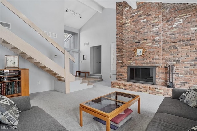 carpeted living room featuring beam ceiling, a fireplace, high vaulted ceiling, and rail lighting