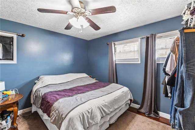 bedroom with wood-type flooring, ceiling fan, and a textured ceiling