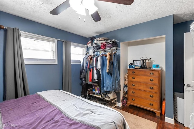 bedroom with dark hardwood / wood-style flooring, ceiling fan, a closet, and a textured ceiling