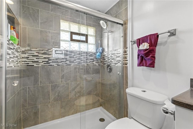 bathroom with vanity, a shower with shower door, and toilet