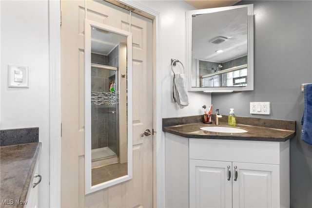 bathroom featuring vanity and an enclosed shower