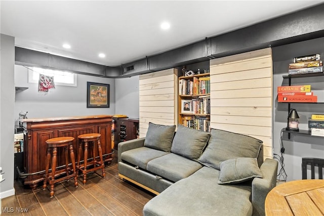 living room with dark hardwood / wood-style flooring and bar area