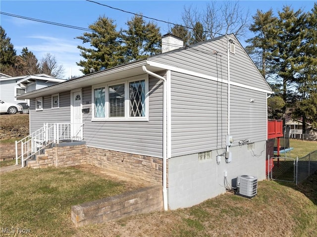 view of property exterior with a lawn and central air condition unit