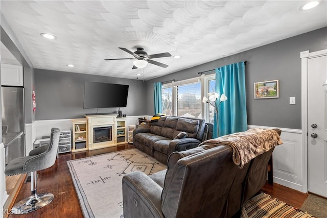 living room featuring ceiling fan and dark hardwood / wood-style floors