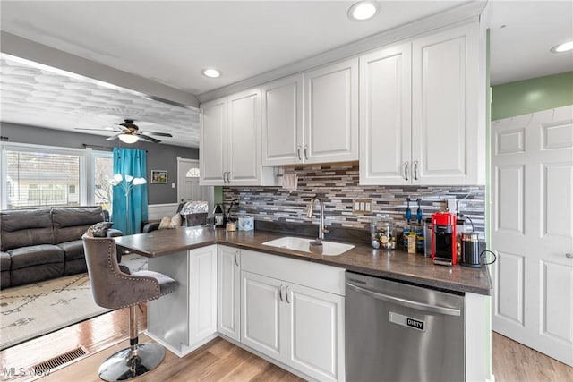 kitchen featuring white cabinetry, stainless steel dishwasher, light hardwood / wood-style floors, and sink