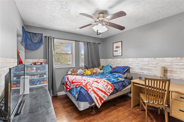 bedroom featuring ceiling fan, dark wood-type flooring, and a textured ceiling