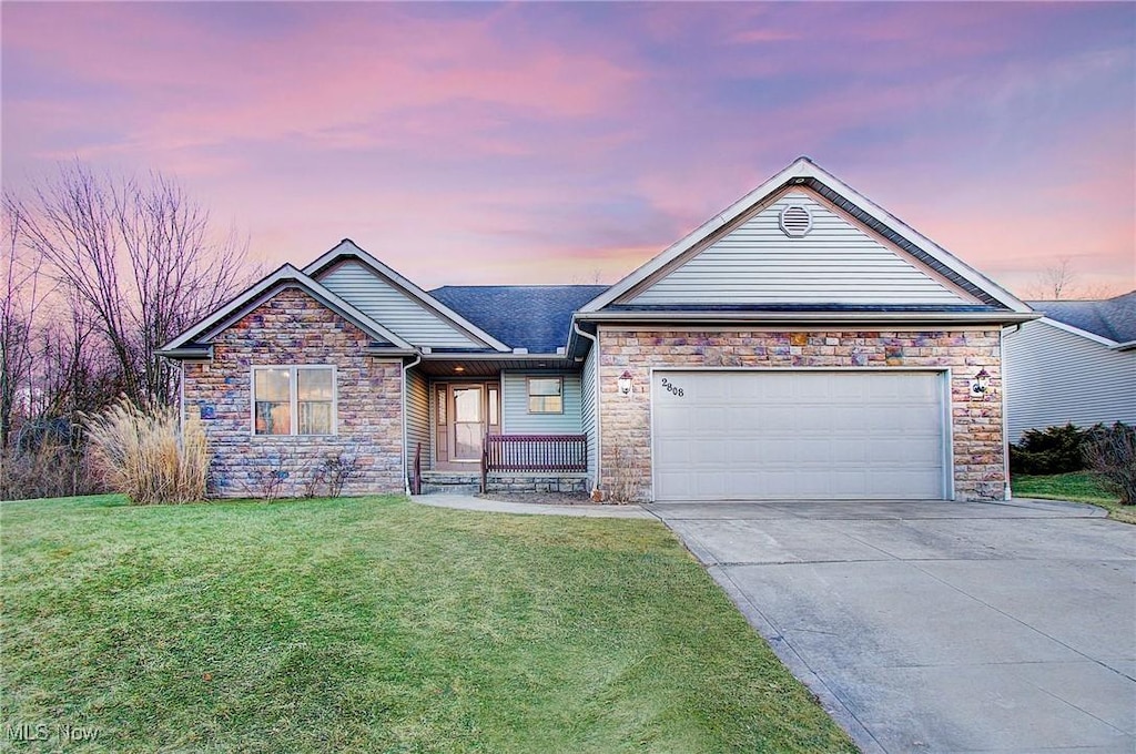 view of front of property with a garage and a lawn