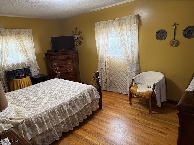 bedroom featuring light hardwood / wood-style floors and a textured ceiling