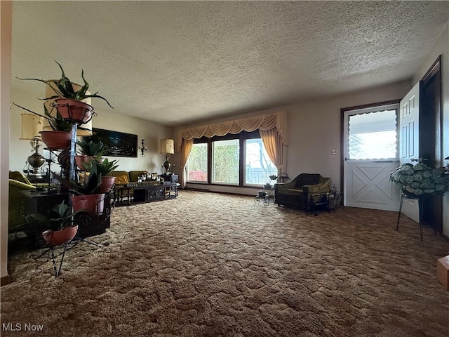 living room featuring carpet, a healthy amount of sunlight, and a textured ceiling