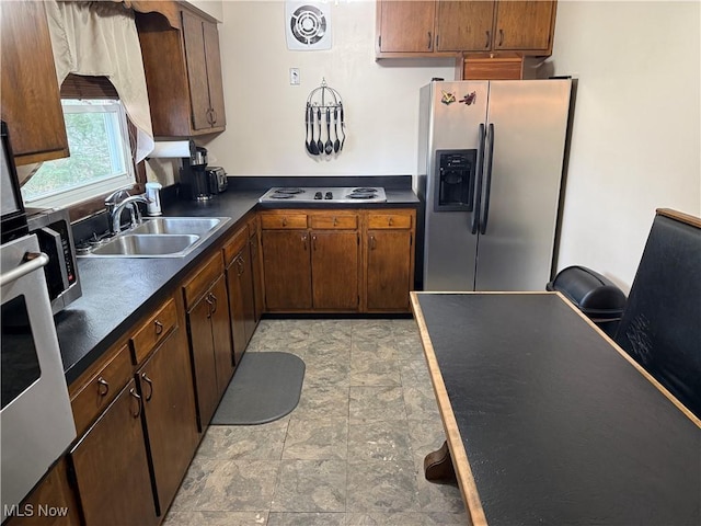 kitchen featuring stovetop, sink, and stainless steel fridge with ice dispenser