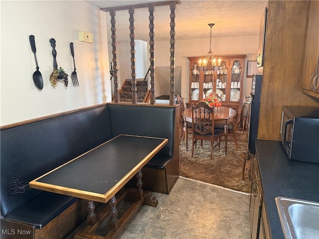 interior space with a notable chandelier, sink, and a textured ceiling