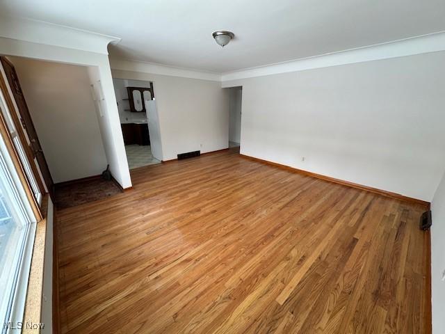 unfurnished room featuring crown molding and hardwood / wood-style flooring