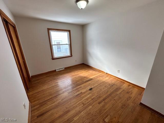 unfurnished room with hardwood / wood-style flooring