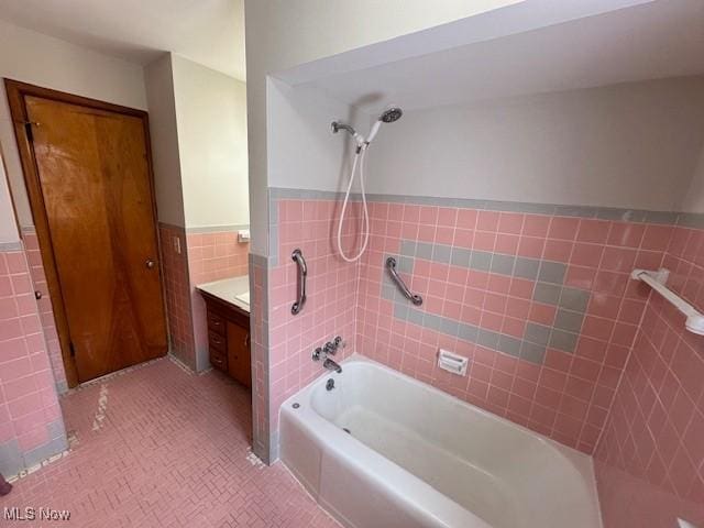 bathroom featuring vanity, tile walls, tile patterned floors, and shower / tub combination