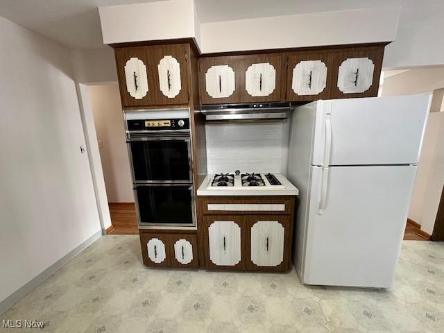 kitchen with dark brown cabinets and white appliances