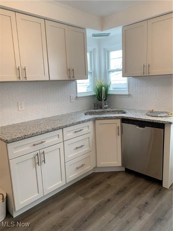 kitchen with sink, dishwasher, white cabinetry, light stone counters, and decorative backsplash