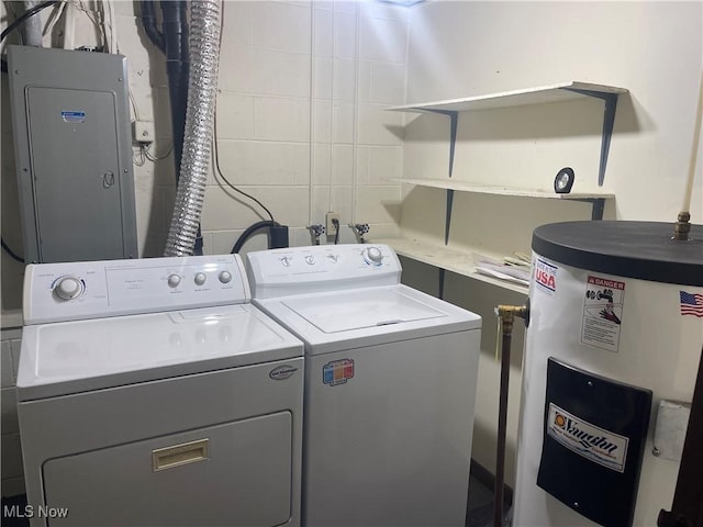 washroom with washing machine and clothes dryer, electric panel, and water heater