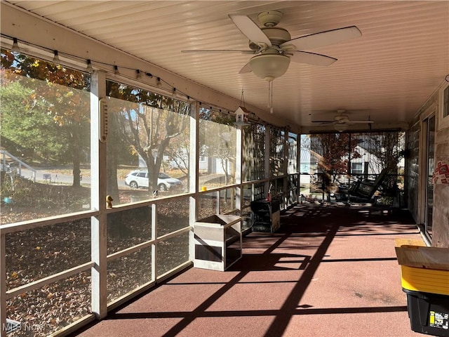 unfurnished sunroom with ceiling fan