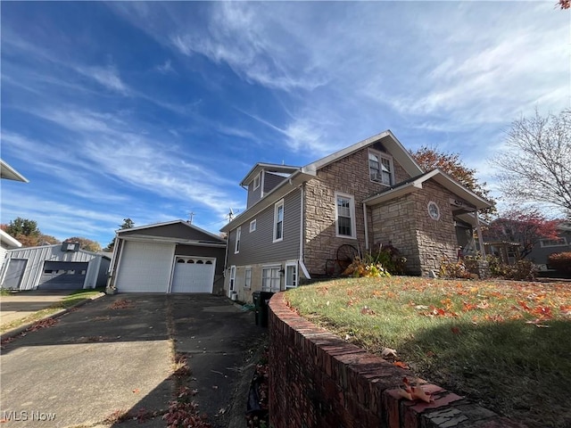 view of side of home with a garage, an outdoor structure, and a yard