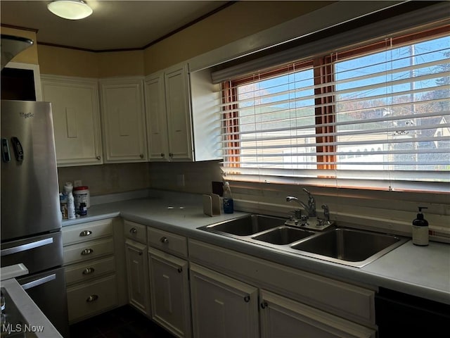 kitchen with sink, white cabinets, and stainless steel refrigerator