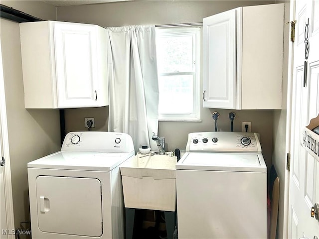 clothes washing area featuring cabinets, separate washer and dryer, and sink