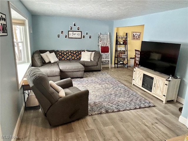 living room with a textured ceiling and light hardwood / wood-style floors