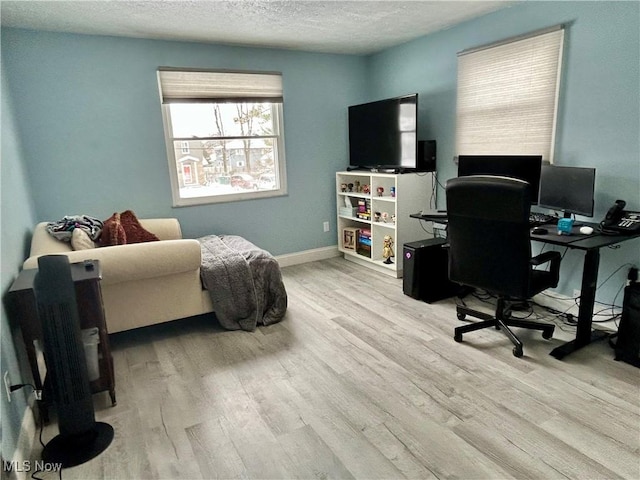 home office featuring a textured ceiling and light hardwood / wood-style flooring