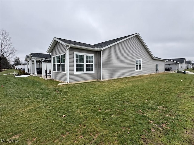 view of side of home with a pergola, a patio area, and a lawn