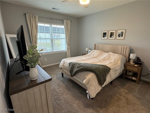 carpeted bedroom featuring ceiling fan and a textured ceiling