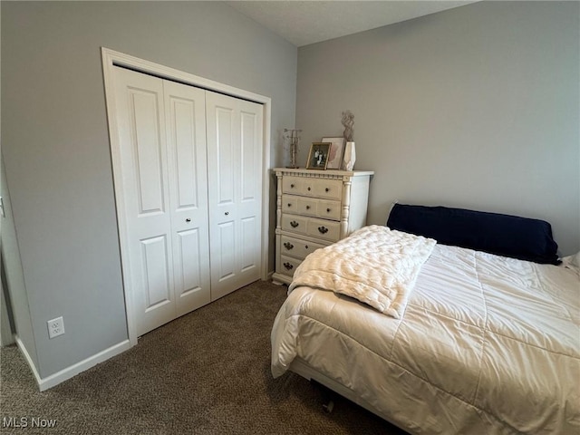 bedroom with dark colored carpet and a closet