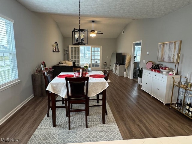 dining space featuring a notable chandelier, vaulted ceiling, dark hardwood / wood-style floors, and a textured ceiling