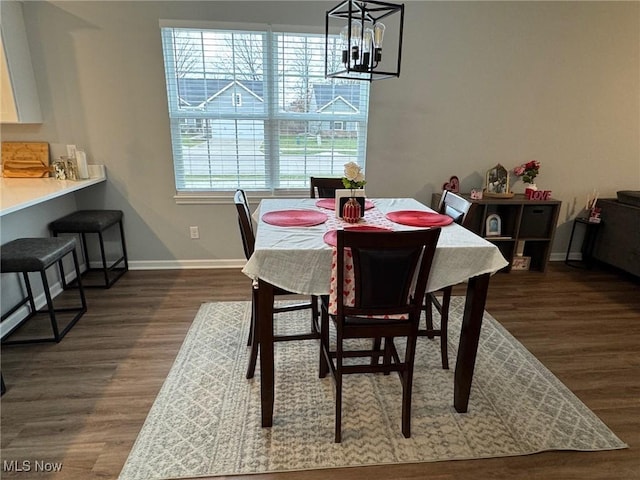 dining space featuring an inviting chandelier and dark hardwood / wood-style flooring