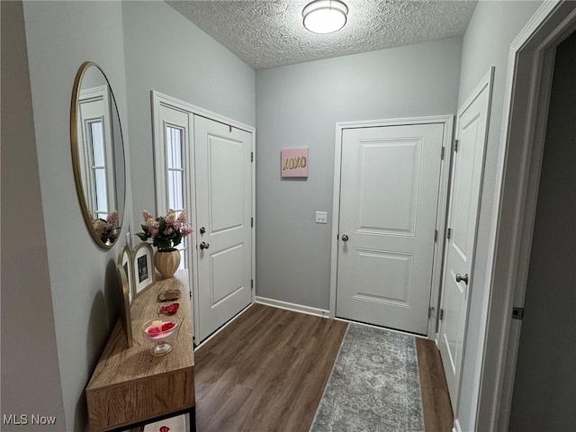 foyer entrance featuring dark hardwood / wood-style floors and a textured ceiling