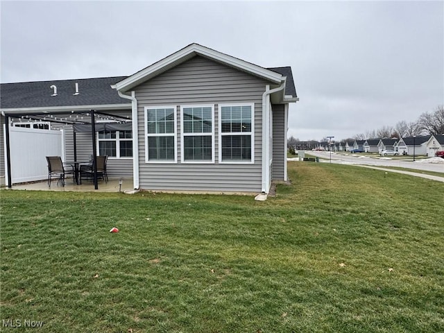 back of house featuring a patio, a pergola, and a lawn