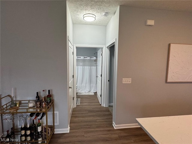 corridor featuring dark wood-type flooring and a textured ceiling