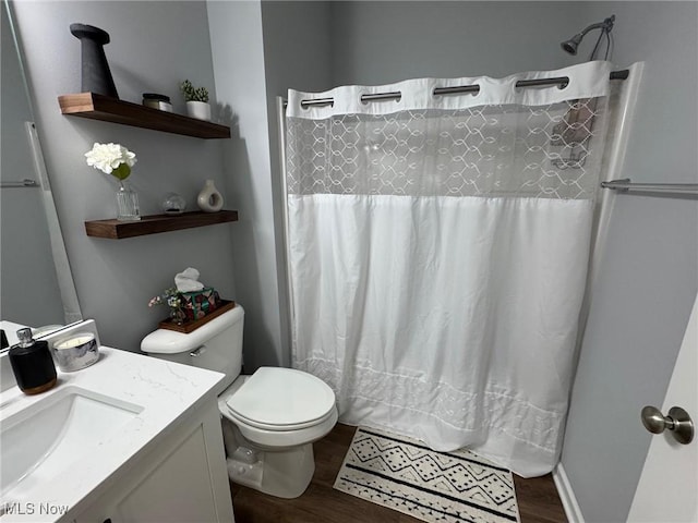 bathroom with hardwood / wood-style flooring, vanity, curtained shower, and toilet