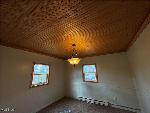 carpeted spare room with baseboard heating, plenty of natural light, wooden ceiling, and a wainscoted wall