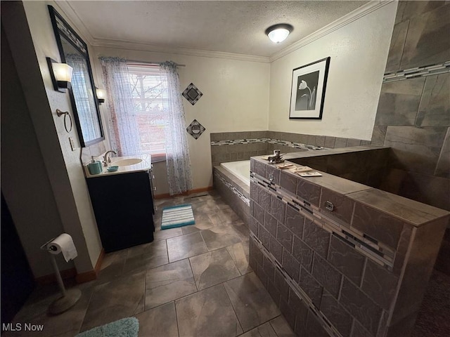 full bathroom with vanity, baseboards, ornamental molding, a textured ceiling, and a bath