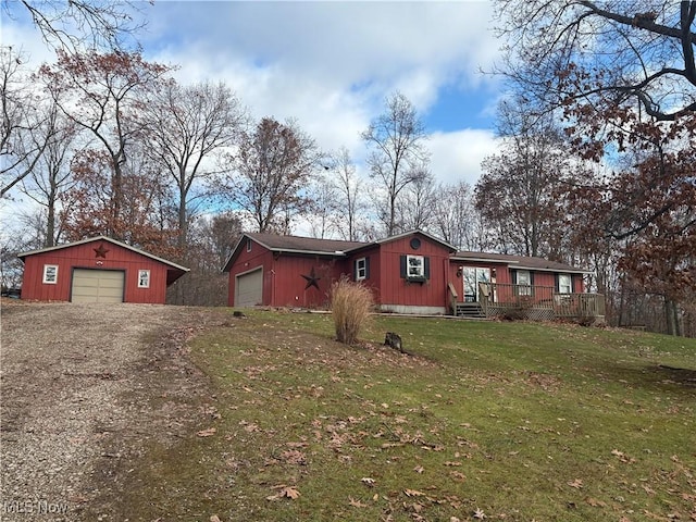 view of front facade with a garage, driveway, a deck, and a front lawn