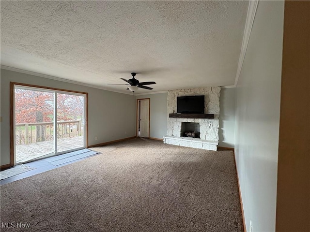 unfurnished living room featuring baseboards, carpet, ornamental molding, a fireplace, and a ceiling fan