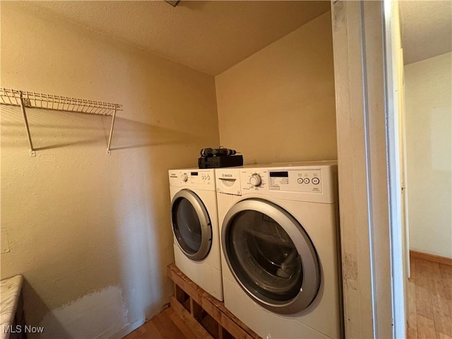 clothes washing area with laundry area, independent washer and dryer, and wood finished floors