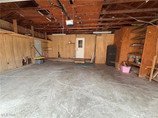 garage with wood walls and a garage door opener