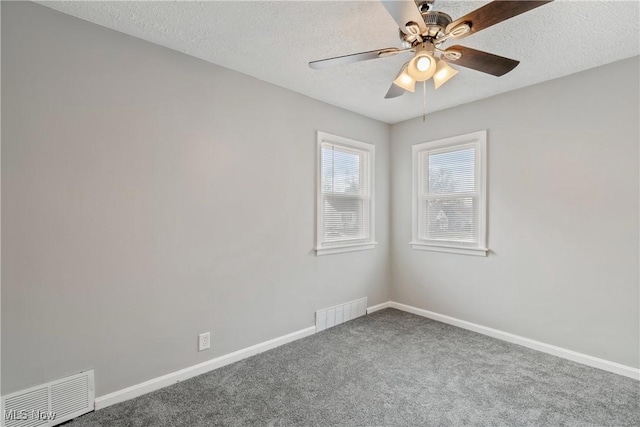 spare room featuring ceiling fan, carpet, and a textured ceiling