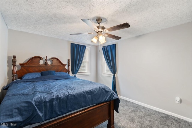 bedroom with ceiling fan, carpet floors, and a textured ceiling