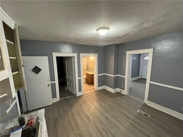 unfurnished room with dark hardwood / wood-style flooring and a textured ceiling