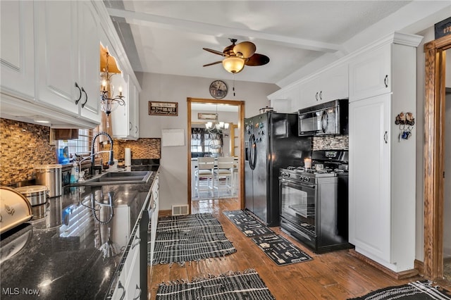 kitchen featuring a healthy amount of sunlight, white cabinetry, sink, black appliances, and dark wood-type flooring