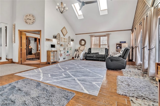 living room with hardwood / wood-style floors, a notable chandelier, a skylight, and high vaulted ceiling